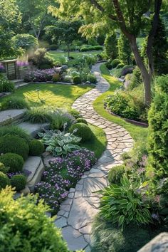 a garden with lots of green plants and flowers on the side of it, surrounded by trees