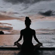 a woman sitting in the middle of a body of water