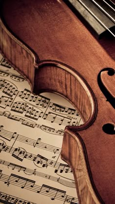 an old violin sitting on top of sheet music