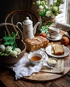 a wooden table topped with plates and bowls filled with food next to a cup of tea