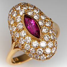 This elegant ring is centered with one (1), bezel set, marquise mixed cut natural ruby. The ruby is bordered with fifty-two (52), bead set, round brilliant cut diamonds. The ring has a reverse tapered "knife edge" style shank. The ring measures 19.5mm at the top, rises 7.7mm above the finger, tapering to 2.7mm wide and 1.6mm thick at the base of the shank. This ring is currently a size 6.75. The ring shows a lovely soft patina. Luxury Marquise Ruby Ring With Diamonds, Luxury Ruby Ring Marquise Cut For Formal Events, Luxury Marquise Red Ruby Ring, Luxury Ruby Marquise Cut Ring For Formal Occasions, Classic Marquise Ruby Ring With Brilliant Cut, Luxury Marquise Cut Ruby Ring For Formal Occasions, Luxury Ruby Marquise Cut Rings, Luxury Marquise Ruby Ring, Luxury Red Marquise Ruby Ring