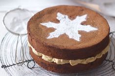 there is a cake with white frosting on the top and bottom, sitting on a wire rack