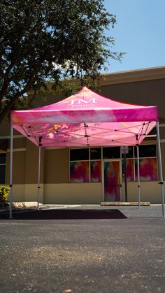 a pink tent sitting in front of a building