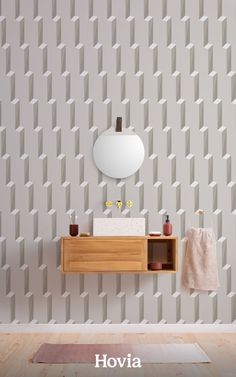 a bathroom with a sink, mirror and towel on the shelf in front of it