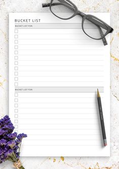 a notepad with glasses on it next to purple flowers