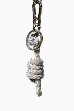 a rope with a compass hanging from it's end on a white background in the shape of a keychain