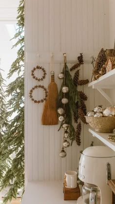 christmas decorations hanging on the wall in a kitchen with pine cones and other holiday decor