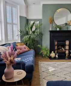 a living room filled with furniture and a fire place next to a mirror on the wall