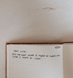 a piece of paper with writing on it sitting in front of a white wall next to a clock