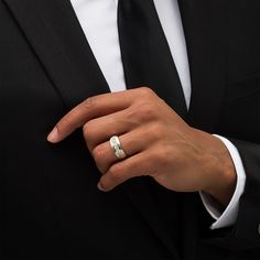 a man in a suit and tie wearing a wedding ring