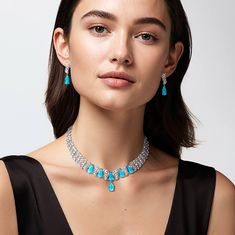 A breath-taking piece that combines bold design with exquisite detailing. The stunning necklace features light blue, pear shaped stones, each set to capture and reflect light beautifully. Intertwined with dazzling ice white Diamondeau®, flawless simulated diamond, the intricate swirls create a captivating interplay of sparkle and color. Complete your look by pairing this necklace with the matching earrings, ensuring an unforgettable appearance. Light Blue Crystal Jewelry For Formal Occasions, Elegant Light Blue Necklace For Wedding, Elegant Light Blue Wedding Necklaces, Elegant Turquoise Jewelry Sets For Wedding, Elegant Turquoise Wedding Jewelry Sets, Elegant Turquoise Jewelry Set For Party, Elegant Blue Jewelry Sets With Diamond Accents, Elegant Turquoise Necklace With Diamond Accents, Elegant Turquoise Necklaces With Diamond Accents