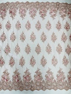 an old pink and white blanket with floral design on the bottom, sitting on a table