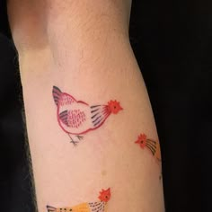 a small tattoo on the arm of a woman's leg with birds and leaves