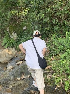 a person with a camera on their back walking along a stream