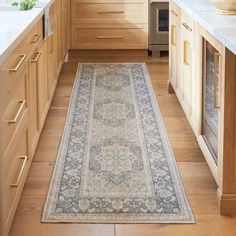 a large rug in the middle of a kitchen with wooden cabinets and countertop space