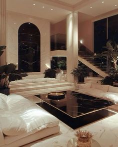 a living room filled with white furniture and lots of windows next to a stair case