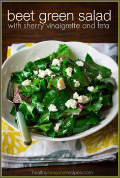 a white bowl filled with greens and feta cheese