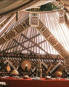 the inside of a yurt with various items on it and decorations hanging from the ceiling