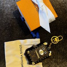 an orange book and keychain are sitting on the floor next to a bag