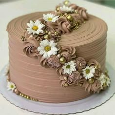 a chocolate cake decorated with flowers and pearls