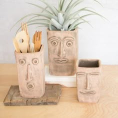 a planter with two faces on it and utensils in front of it