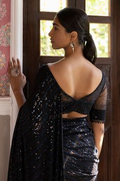 Beautiful black sequin embroidered saree. It comes with a sequined work all over, a bootcut neck, and a sleeveless sequined blouse. It is best suited for night parties & weddings. Shop designer saris online in the USA from Pure Elegance Disclaimer: The actual product may vary slightly from the image. These are custom orders, hence expect slight variation in color, placement of the motif or buta. ESTIMATED DELIVERYBecause this is a custom order, it would take about 4 weeks from the date of purcha Sarees Black, Sequined Blouse, Dresses Anarkali, Night Parties, Suits Indian, Boat Neck Blouse, Sharara Suits, Designer Kurta, Embroidered Saree