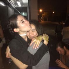 two women hugging each other outside at night