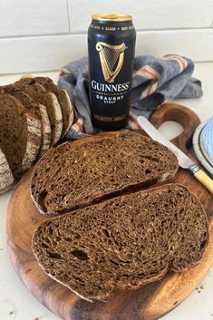 sliced bread on a wooden cutting board next to a bottle of guinness and two slices of bread