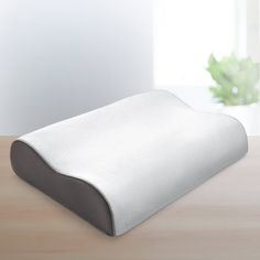 a white pillow sitting on top of a wooden table