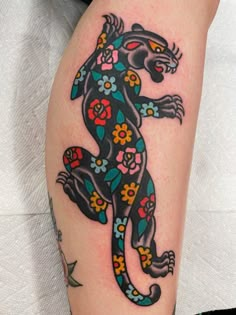 a colorful lizard tattoo on the leg