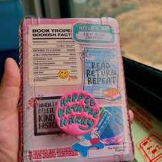 a person holding up a book with stickers on it