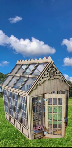 a small house made out of wood and glass in the middle of a green field