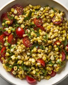 a white bowl filled with corn and tomatoes