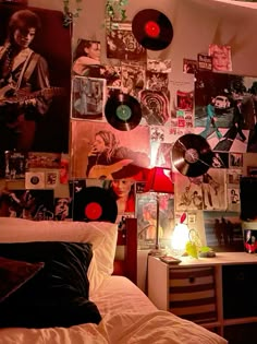 a bedroom with lots of records and pictures on the wall above the bed in front of it