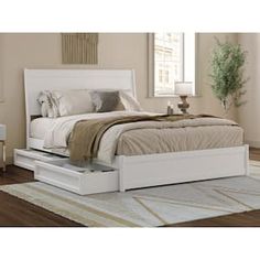 a white bed sitting on top of a wooden floor