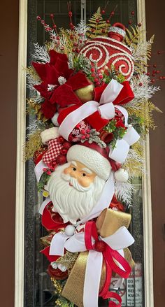 a christmas door hanger with santa clause and red, white and gold decorations on it