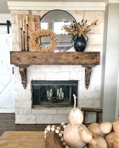 a fireplace with some plants and vases on top of the mantel above it