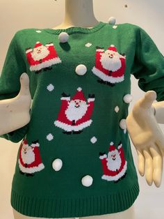 a green christmas sweater with santa claus and snowflakes on the chest, along with white gloves