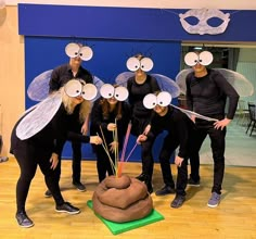 several people in costumes are posing for a photo with fake bugs on their heads and eyes