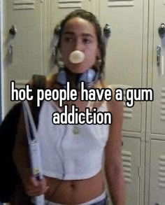 a woman with headphones blowing bubbles in front of lockers that says hot people have a gum addition