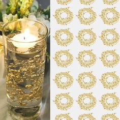 a candle that is inside of a glass with some flowers in the background and gold foil on it