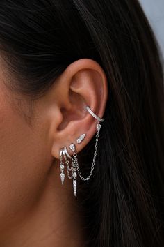 The Maya Spike Stud Earring in 925 Sterling Silver is the perfect blend of subtle elegance and modern style. Featuring a similar shape to the Maya Spike Pendant, this delicate stud is adorned with sparkling crystals that catch the light beautifully, adding a touch of brilliance to your ear stack. Sold as a single, it’s ideal for creating a unique, layered look when paired with other earrings. The Maya Stud Earring is perfect for those who love dainty yet impactful jewellery, offering a versatile option that complements any style.Sold As A Single EarringMaterials: 925 Sterling Silver With A Rhodium Plated FinishGems: White Cubic ZirconiaSize: 1cm Length Women Ear Piercings Ideas, Sterling Silver Earring Stack, Helix Placement, Silver Earrings Stack, Earings Piercings Aesthetic, Silver Ear Stack, Silver Earring Stack, Silver Earrings Aesthetic, Climbers Earrings