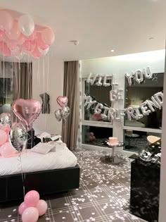 balloons and streamers fill the air in this bedroom decorated for a birthday party with pink and silver decor