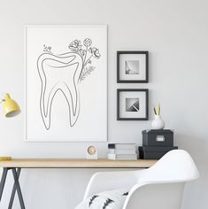 a white chair sitting next to a desk with a drawing on the wall above it