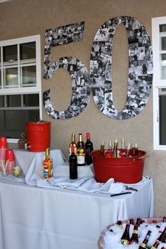 a table topped with lots of bottles of wine next to a sign that says 50