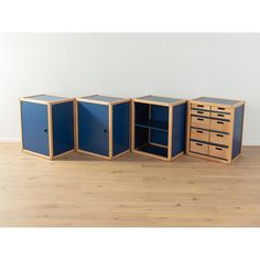 three blue cabinets sitting on top of a wooden floor