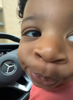 a young child is smiling while sitting in a car