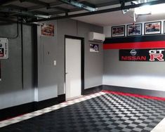 a garage with black and white checkered flooring, pictures on the wall and photos hanging above it