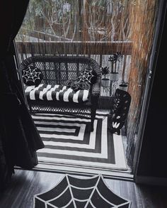 a black and white striped rug in front of a door with spider webs on it