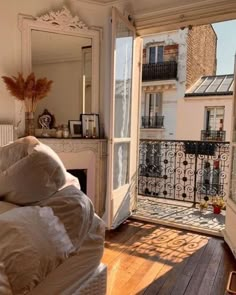 a bedroom with an open door leading to a balcony and patio area that overlooks the city